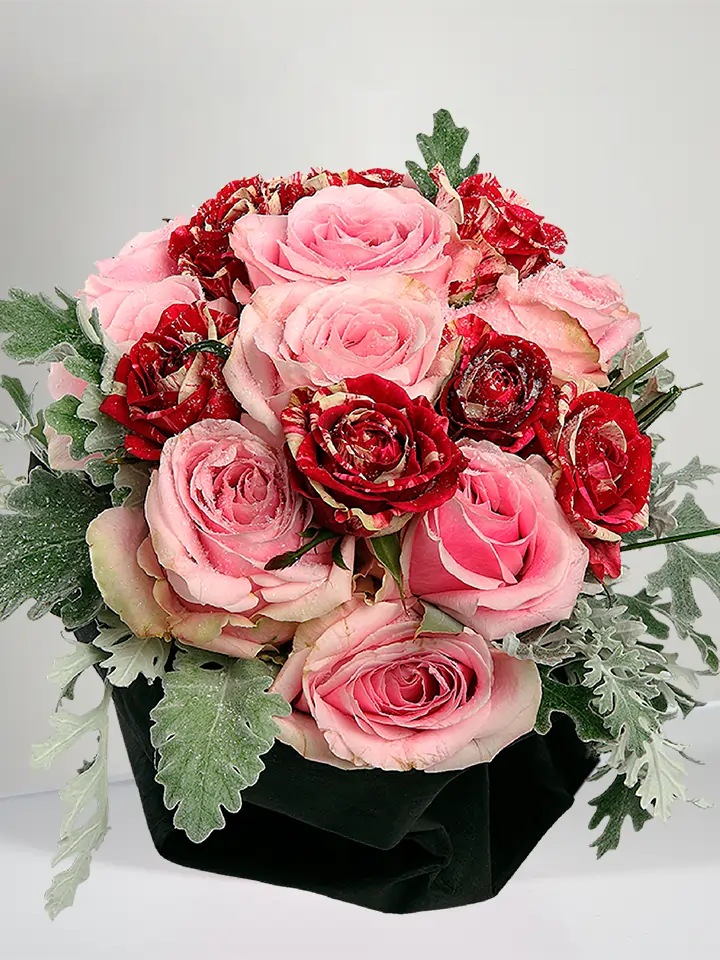 Centrotavola di rose rosa e rosse screziate close up